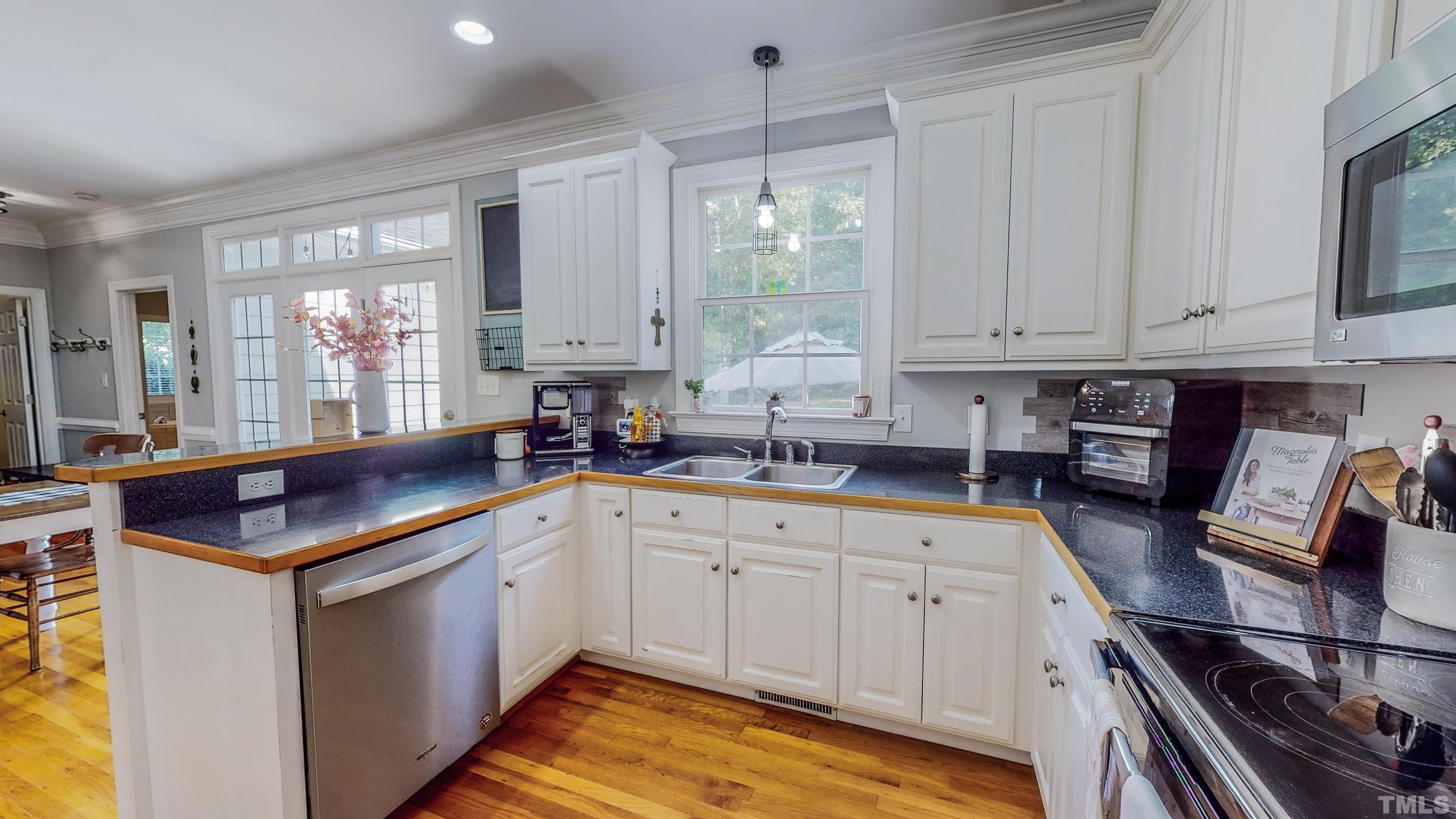226 Fletcher Ridge Road Timberlake, NC 27583 - Photo 14 of 54 a kitchen with stainless steel appliances granite countertop a sink stove and cabinets
