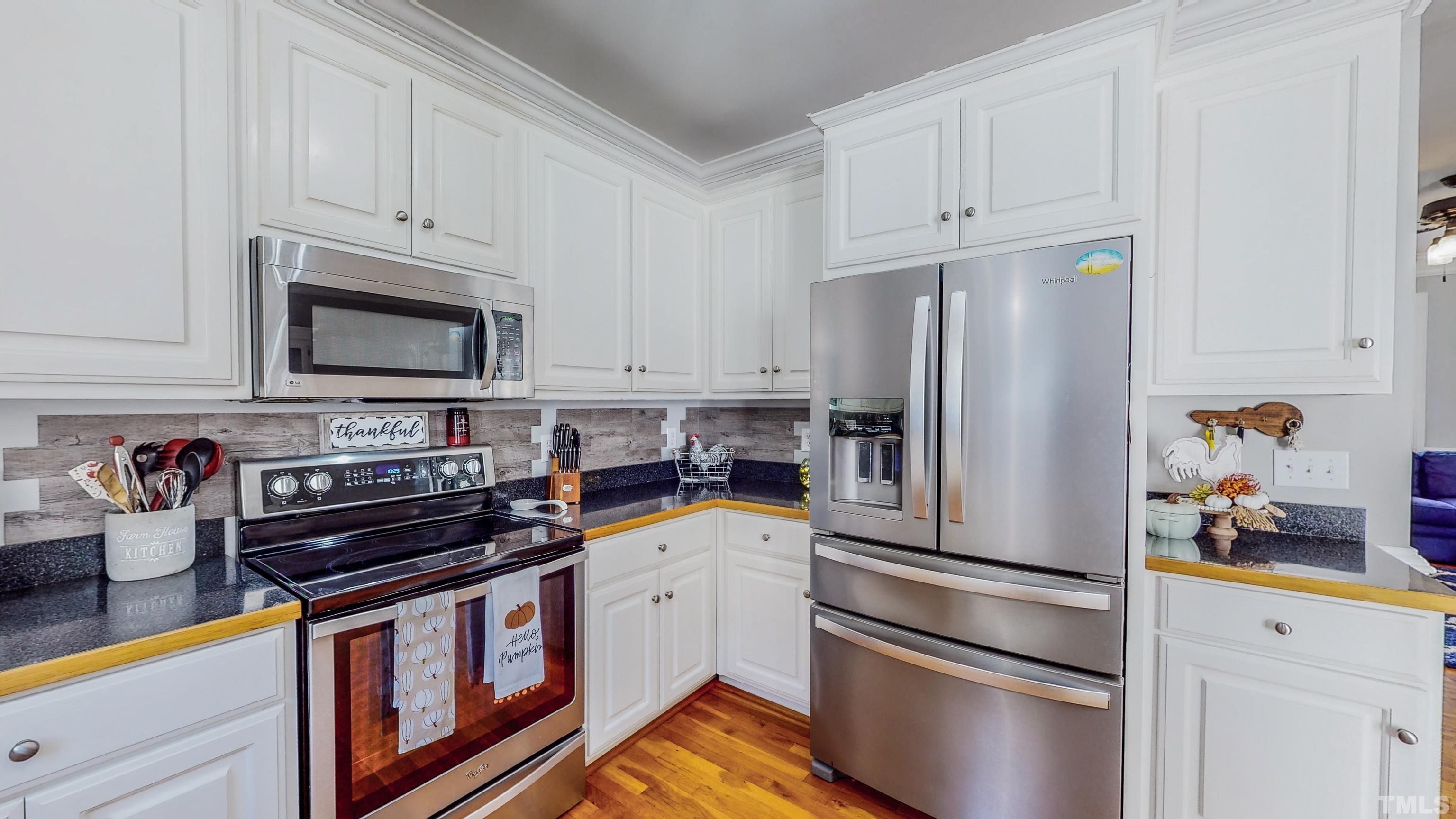 226 Fletcher Ridge Road Timberlake, NC 27583 - Photo 16 of 54 a kitchen with stainless steel appliances a stove a microwave and a refrigerator