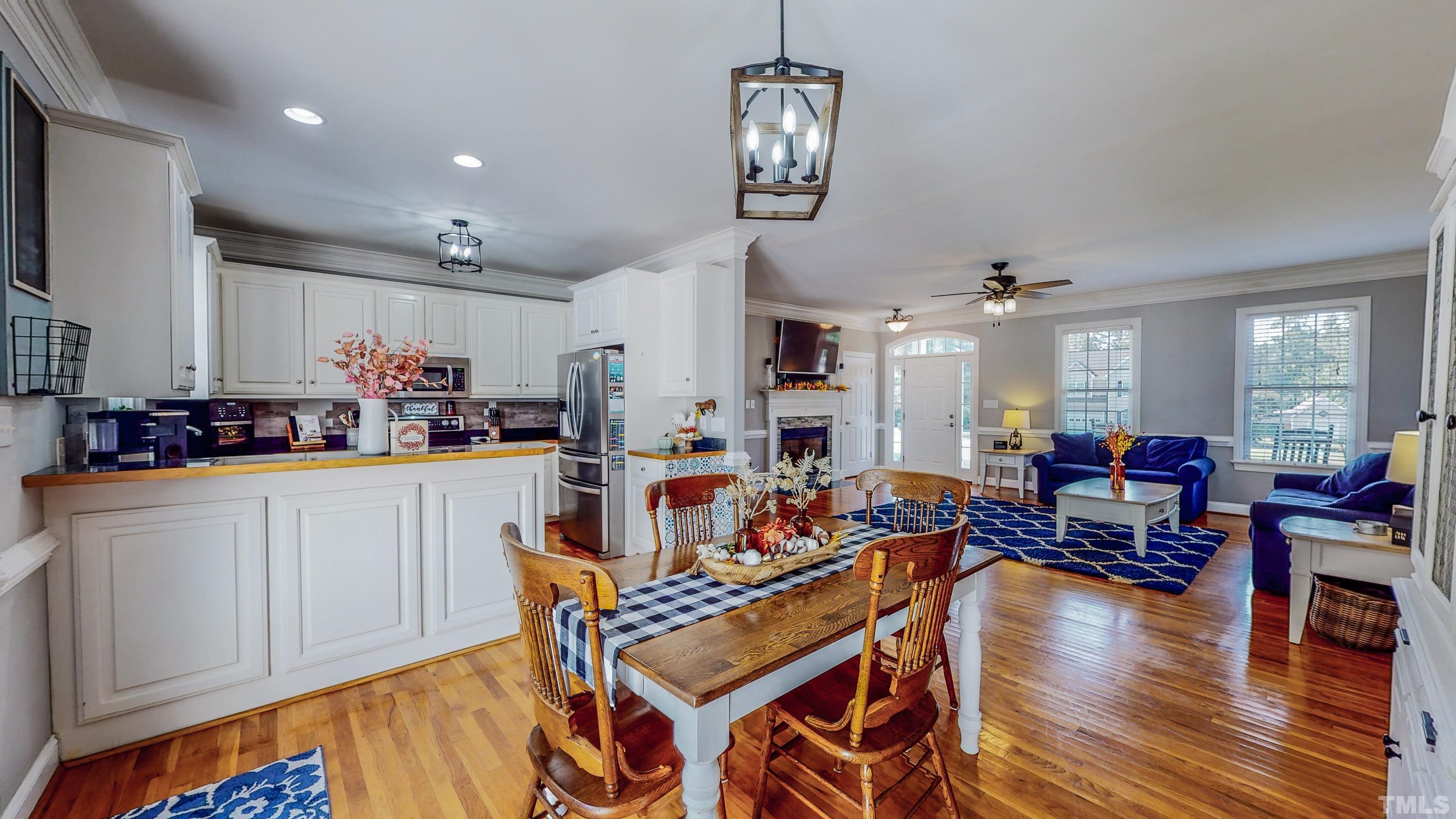 226 Fletcher Ridge Road Timberlake, NC 27583 - Photo 17 of 54 a kitchen with stainless steel appliances granite countertop a stove top oven a dining table and chairs with wooden floor