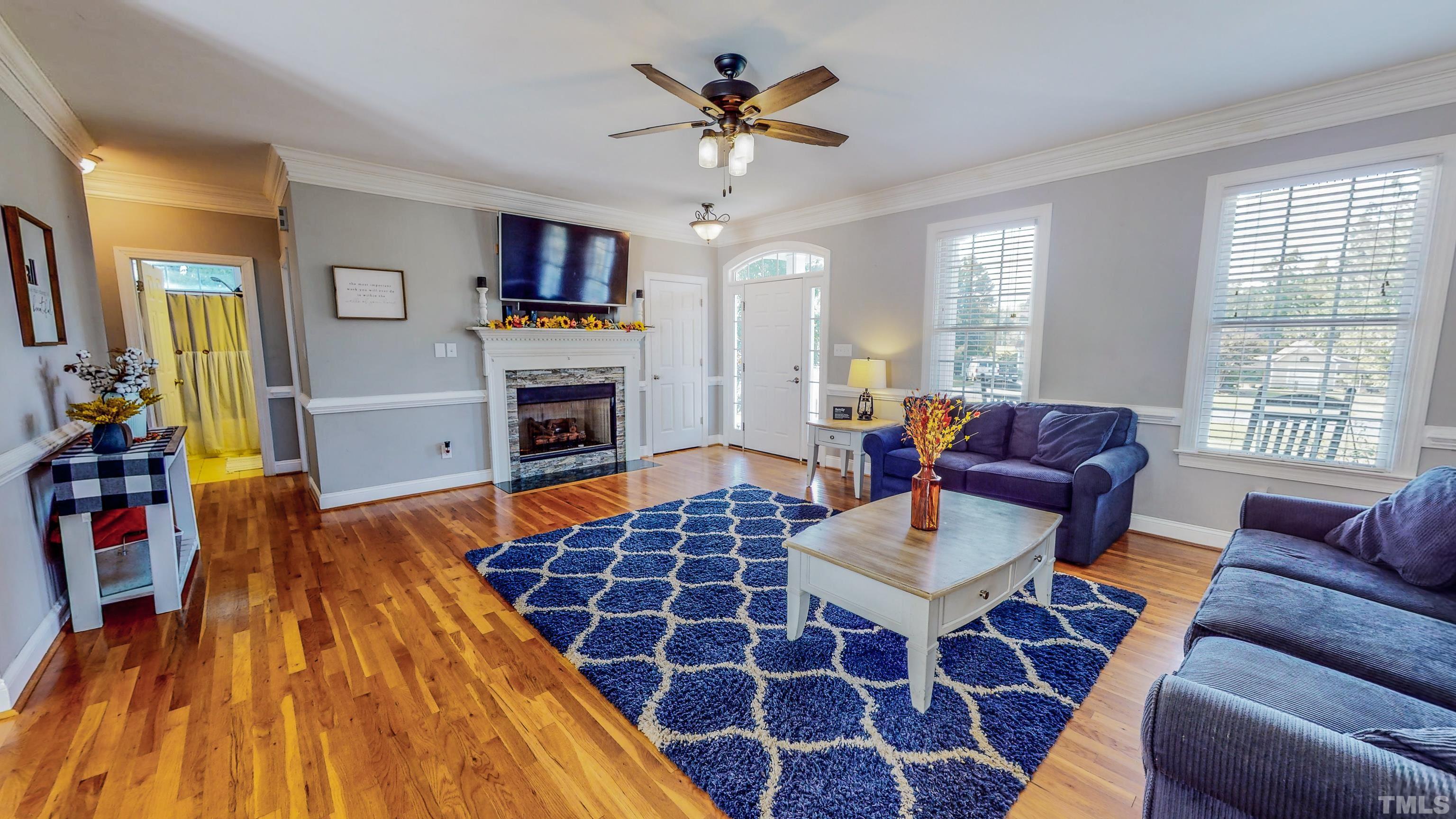 226 Fletcher Ridge Road Timberlake, NC 27583 - Photo 33 of 54 a living room with furniture a flat screen tv and a fireplace