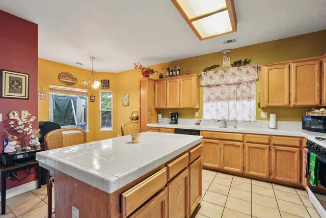 a kitchen with a sink a stove and chairs