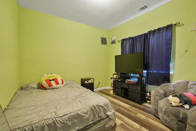 a bedroom with a bed and flat screen tv