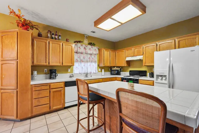 a kitchen with stainless steel appliances a stove a sink refrigerator and a microwave