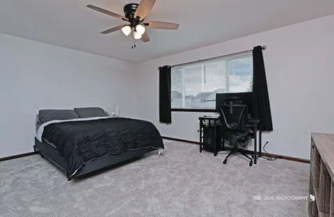 a bedroom with a bed a desk and chair