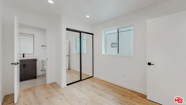 a view of an empty room with a kitchen and a window