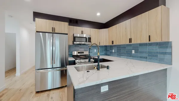 a kitchen with stainless steel appliances a refrigerator sink and microwave