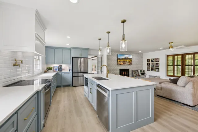 a living room with furniture a fireplace and kitchen view