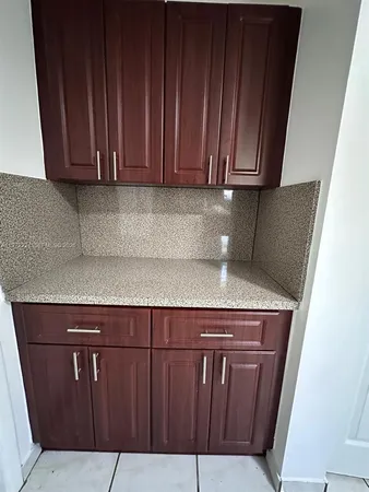 a view of a storage and utility room with wooden floor
