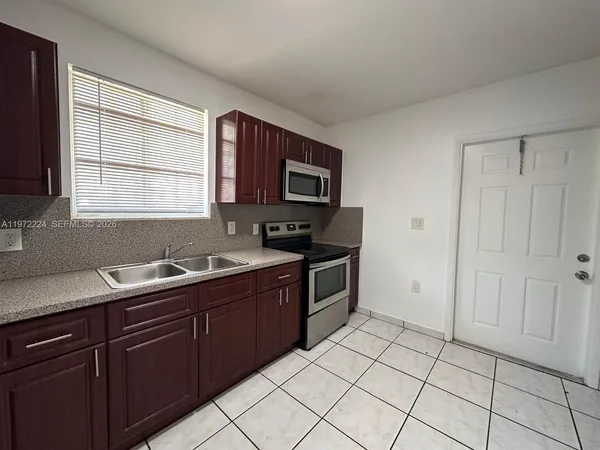 a kitchen with a sink window and cabinets