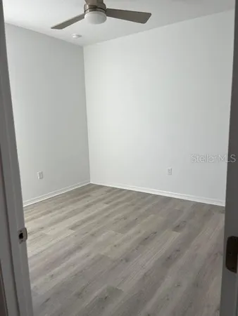 a view of an empty room with wooden floor