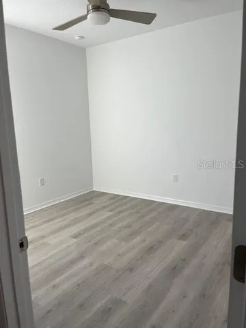 a view of an empty room with wooden floor