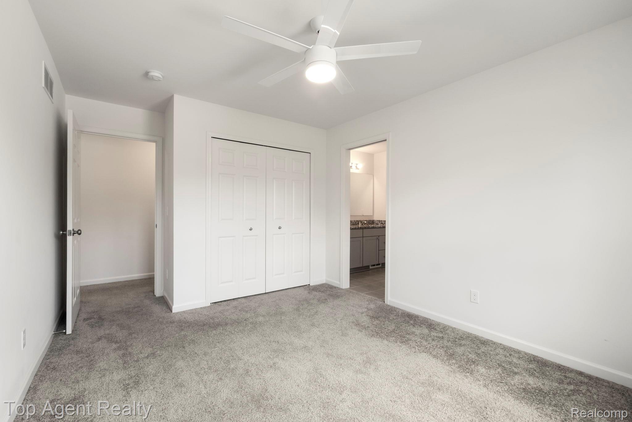 63770 Dequindre Road Washington, MI 48095 - Photo 34 of 61 Spacious room featuring light gray carpet flooring, a white ceiling fan with integrated lighting, and a white bi-fold closet