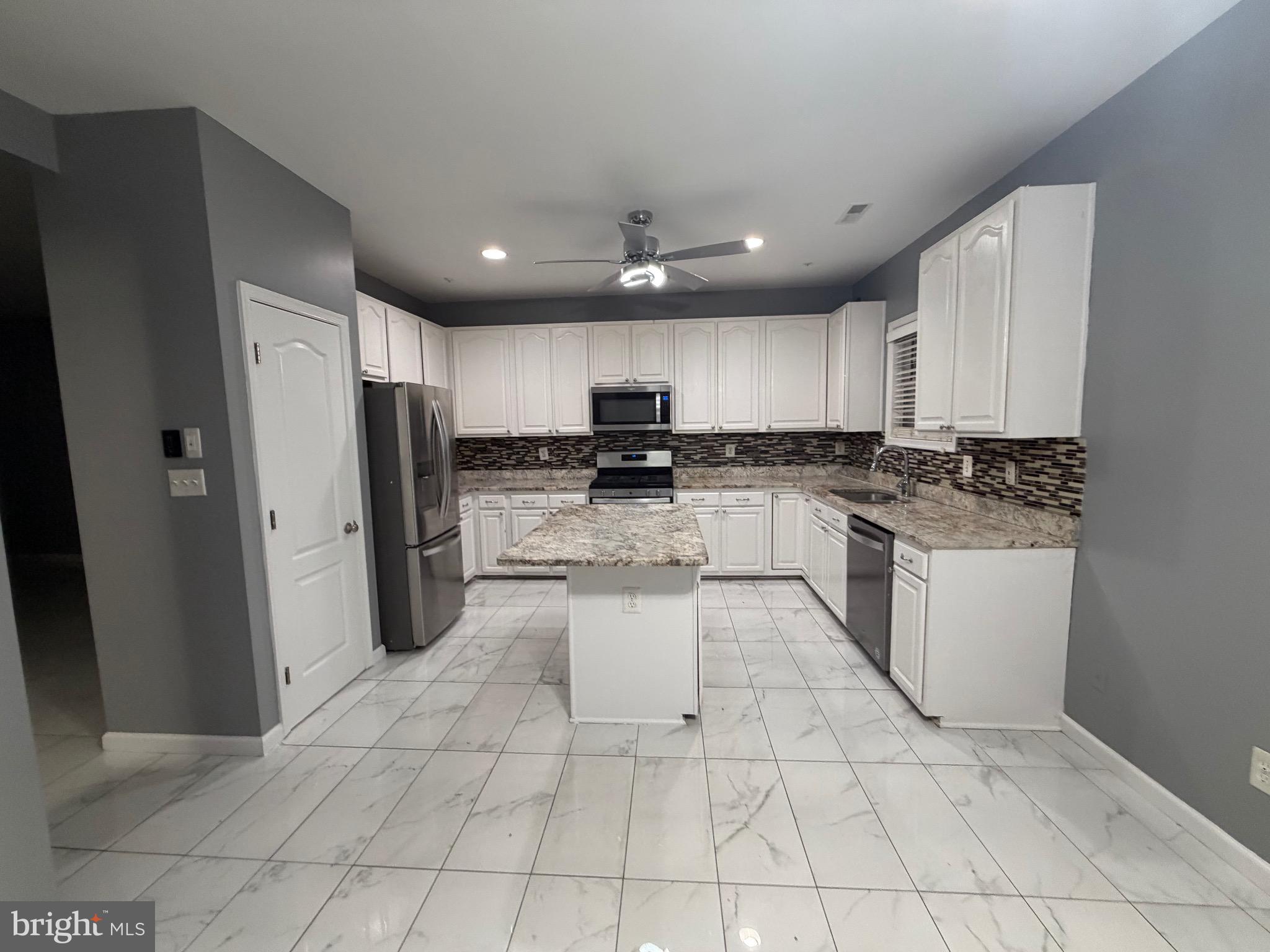 7704 Periwinkle Way Severn, MD 21144 - Photo 15 of 18 a kitchen with stainless steel appliances granite countertop a refrigerator sink and cabinets