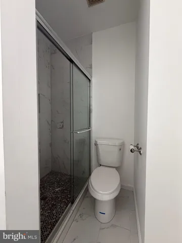 a white toilet sitting next to a shower