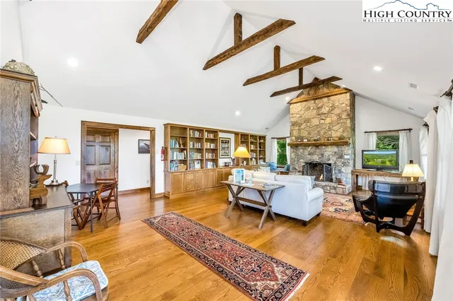 a living room with fireplace furniture and a large window