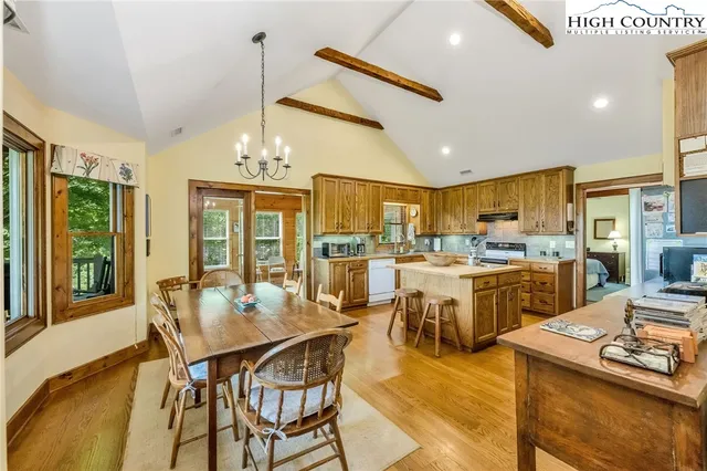 a view of a dining room and livingroom with furniture wooden floor a chandelier
