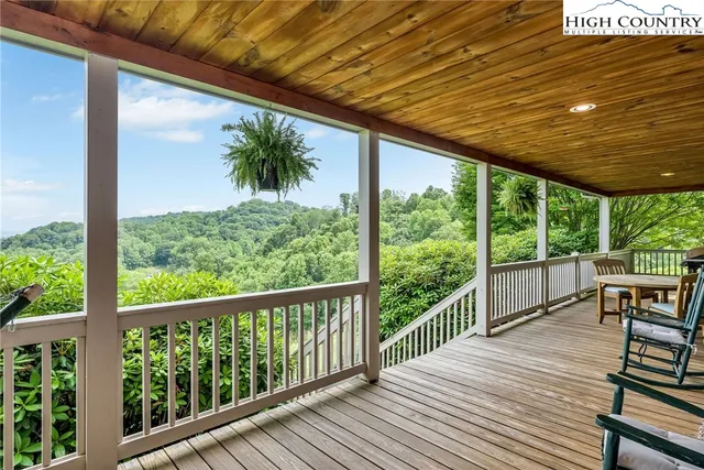 a view of a balcony with chairs and wooden floor