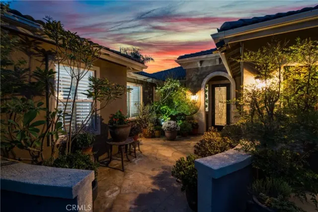 a front view of a house with garden and sitting area