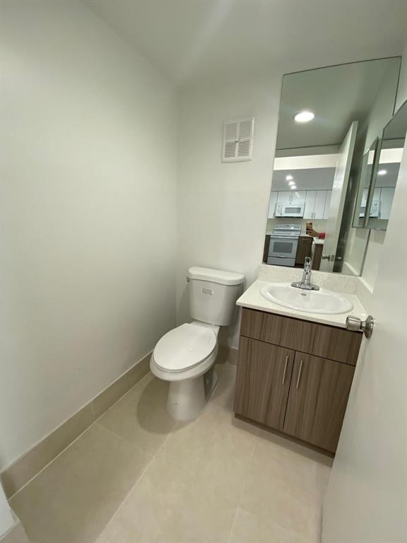 18335 Northwest 68th Avenue, Unit 790220 Hialeah, FL 33015 - Photo 4 of 14 a bathroom with a sink a toilet and mirror