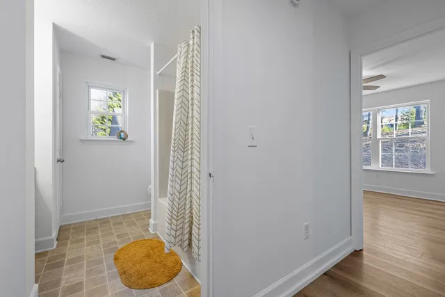 a bathroom with a granite countertop sink a mirror and shower