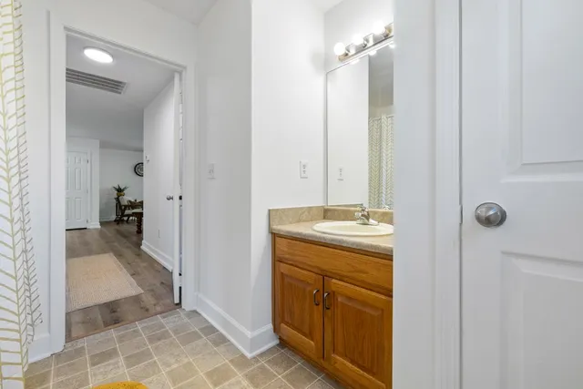 a bathroom with a granite countertop sink a mirror and a shower