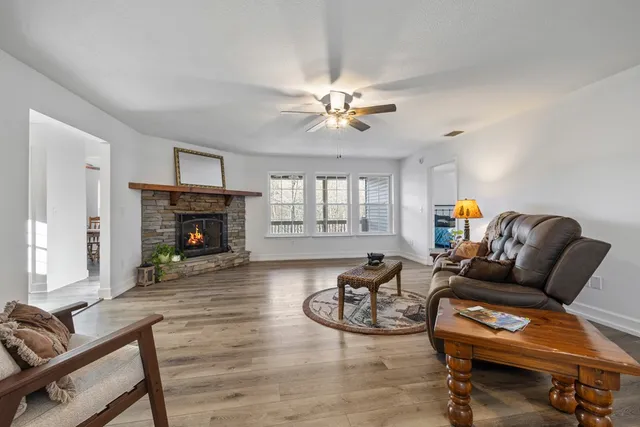 a living room with furniture a fireplace and a chandelier