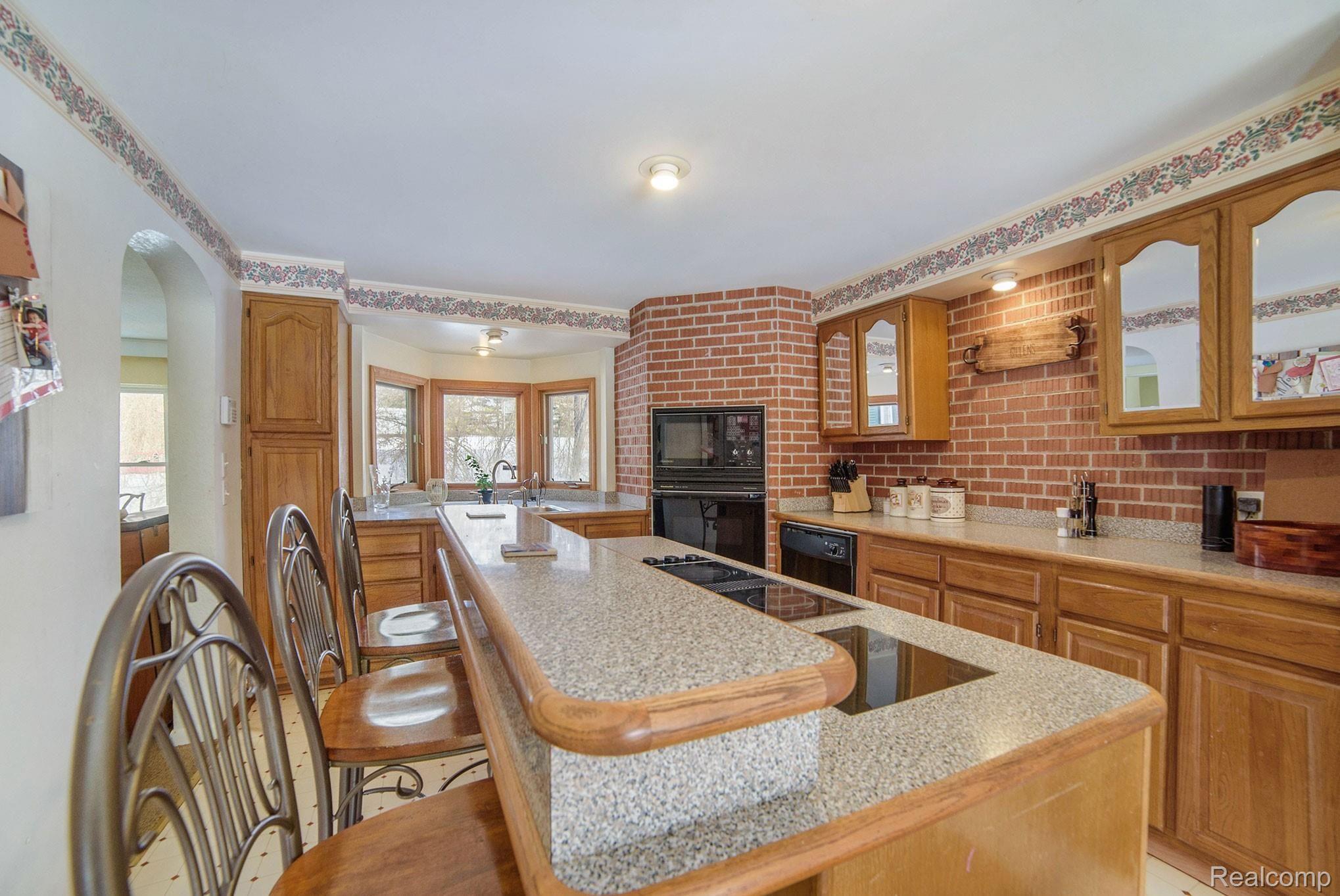 1458 Rochester Road Leonard, MI 48367 - Photo 8 of 32 Beautiful oak cabinetry with additional raised counter space at the breakfast bar, lots of storage