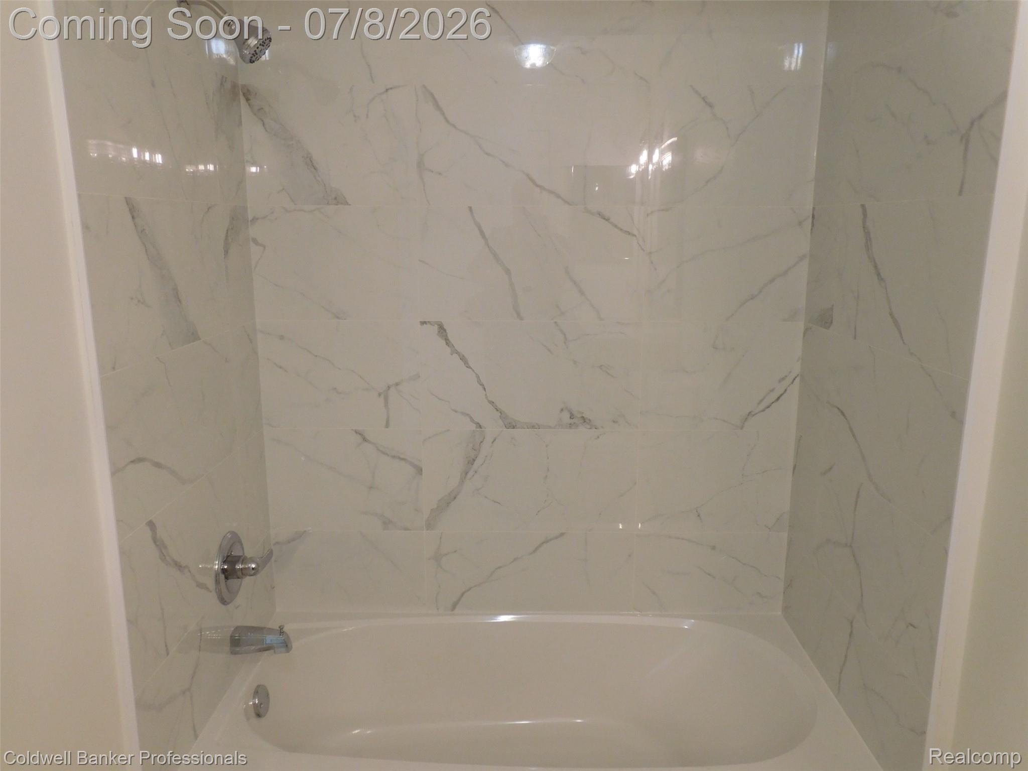 284 East 13 Mile Road Madison Heights, MI 48071 - Photo 16 of 21 Bathtub and shower combination featuring white subway tile surround with gray veining, chrome shower head, and chrome tub spout with single handle control