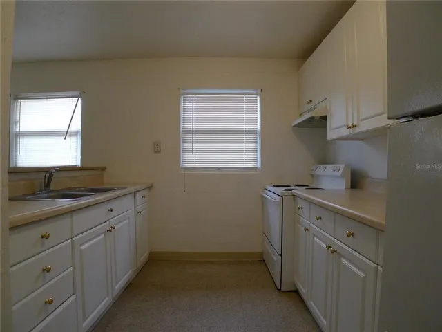 a kitchen with sink cabinets and window