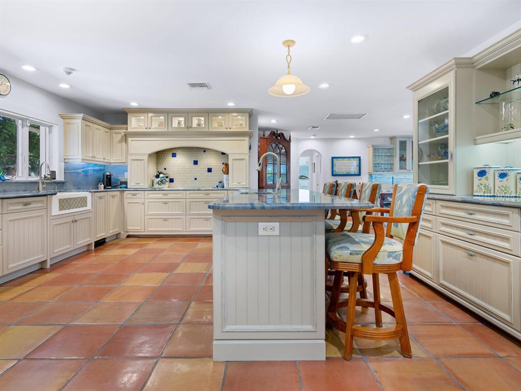 3300 Casey Key Road Nokomis, FL 34275 - Photo 12 of 65 a kitchen with stainless steel appliances kitchen island granite countertop a table and chairs in it