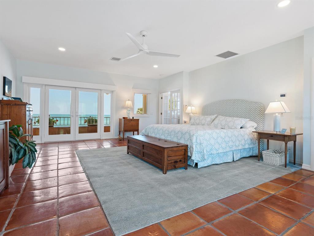3300 Casey Key Road Nokomis, FL 34275 - Photo 19 of 65 a spacious bedroom with a large bed and a chandelier