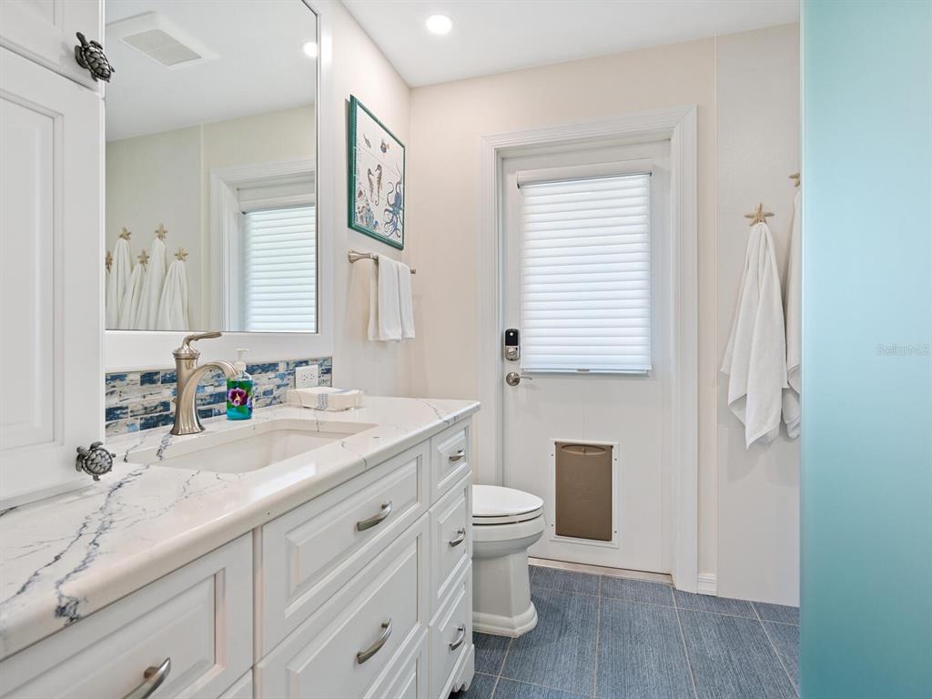 3300 Casey Key Road Nokomis, FL 34275 - Photo 28 of 65 a bathroom with a granite countertop sink toilet a large mirror and shower