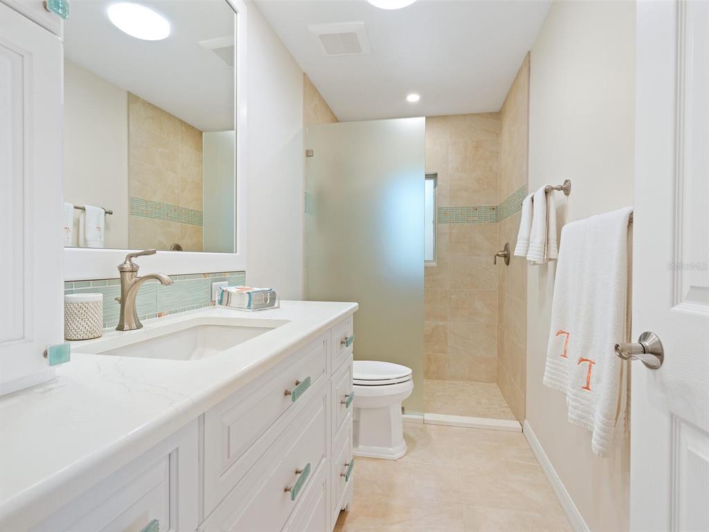 3300 Casey Key Road Nokomis, FL 34275 - Photo 31 of 65 a bathroom with a sink toilet double vanity and shower