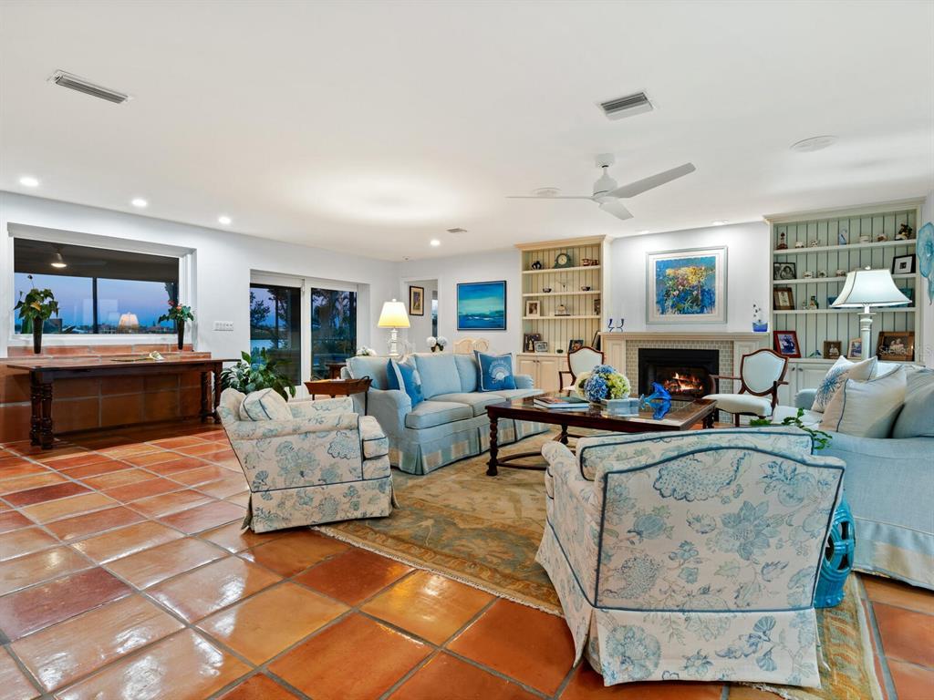 3300 Casey Key Road Nokomis, FL 34275 - Photo 49 of 65 a living room with furniture a fireplace and a flat screen tv