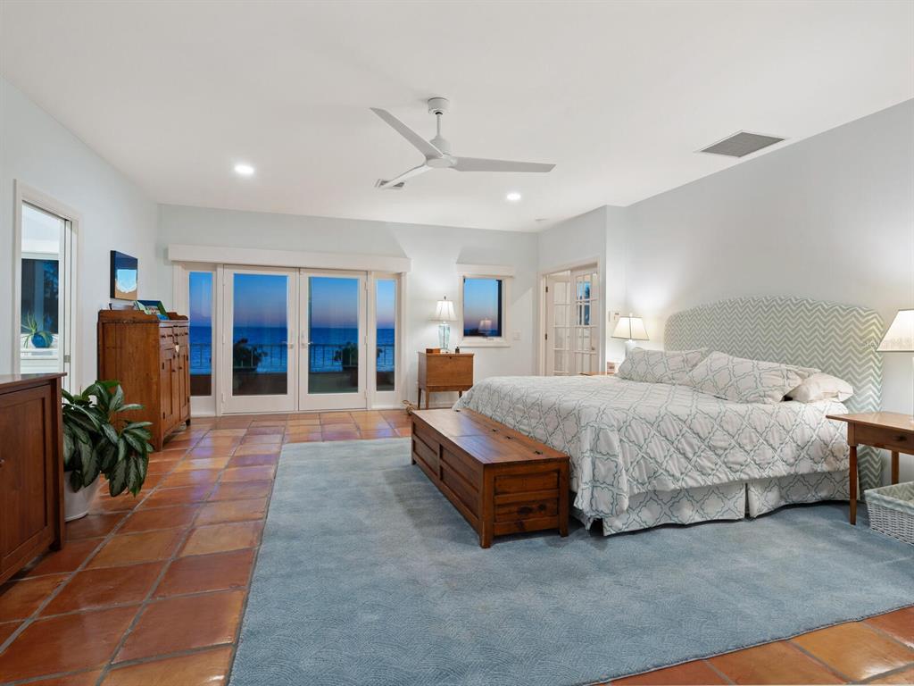 3300 Casey Key Road Nokomis, FL 34275 - Photo 52 of 65 a spacious bedroom with a bed a table and chair