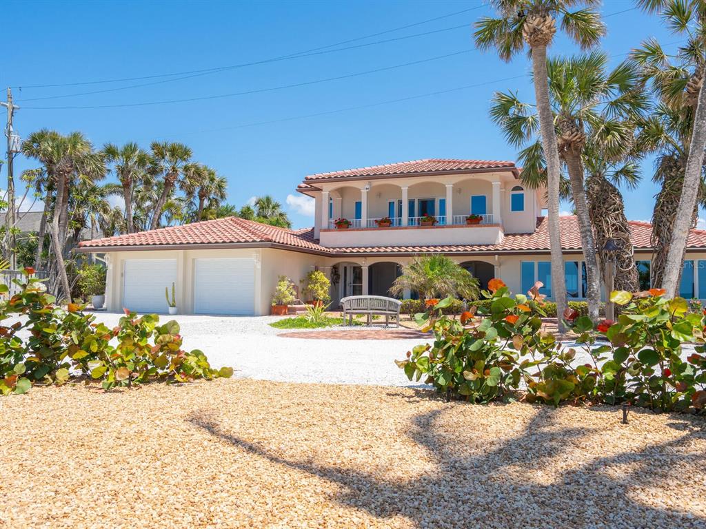 3300 Casey Key Road Nokomis, FL 34275 - Photo 6 of 65 a front view of a house with a yard and a garden