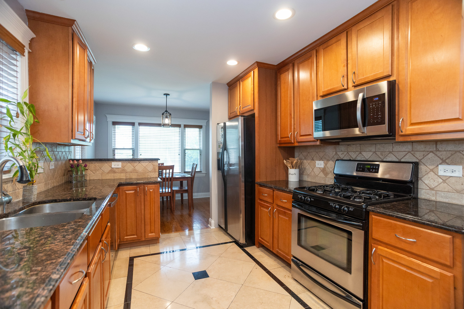 5328 North Rutherford Avenue Chicago, IL 60656 - Photo 13 of 40 a kitchen with stainless steel appliances granite countertop a stove a sink and a microwave