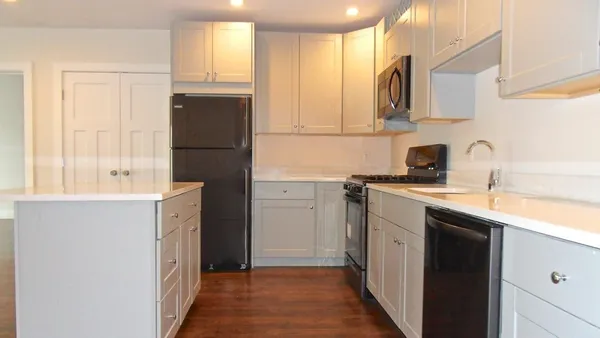 a kitchen with a refrigerator sink and cabinets
