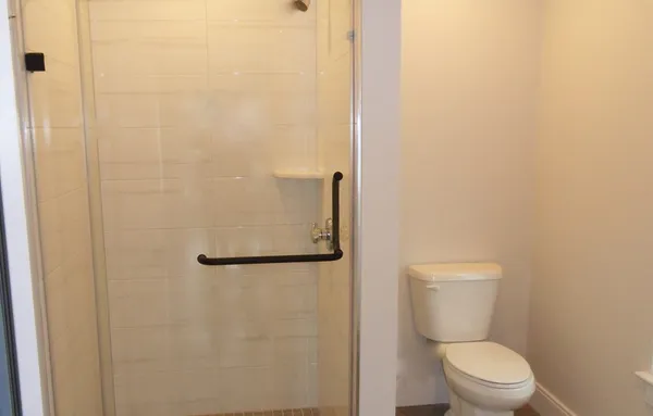 a white toilet sitting next to a shower