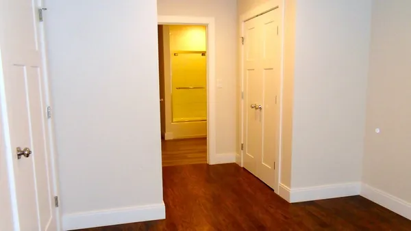 a view of a hallway with wooden floor