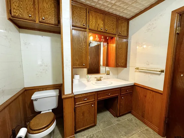 a bathroom with a toilet a sink and a mirror