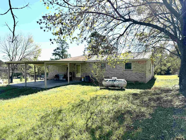 a view of a house with backyard and sitting area
