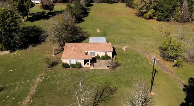 an aerial view of a house with a yard