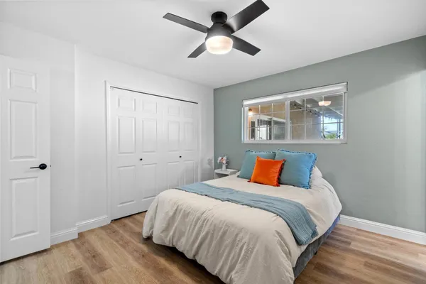 a bedroom with a large bed and a chandelier fan