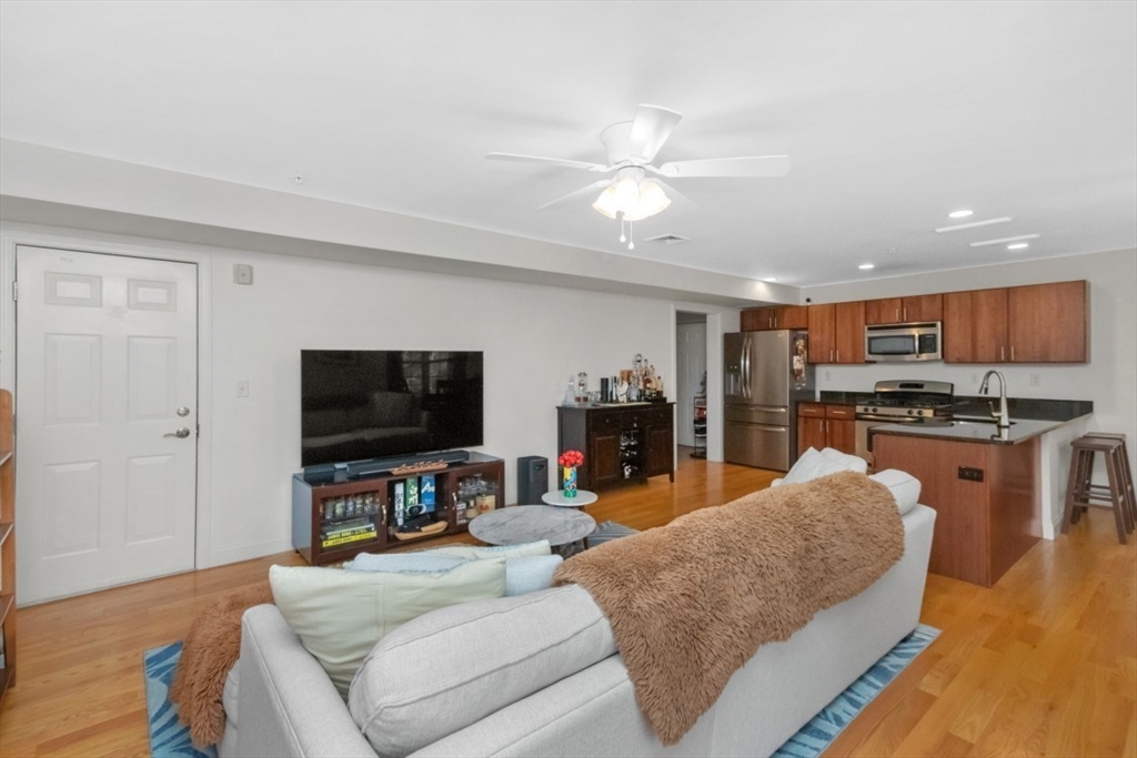 29 Spruce Street, Unit 23 Waltham, MA 02453 - Photo 9 of 26 a living room with furniture and a flat screen tv