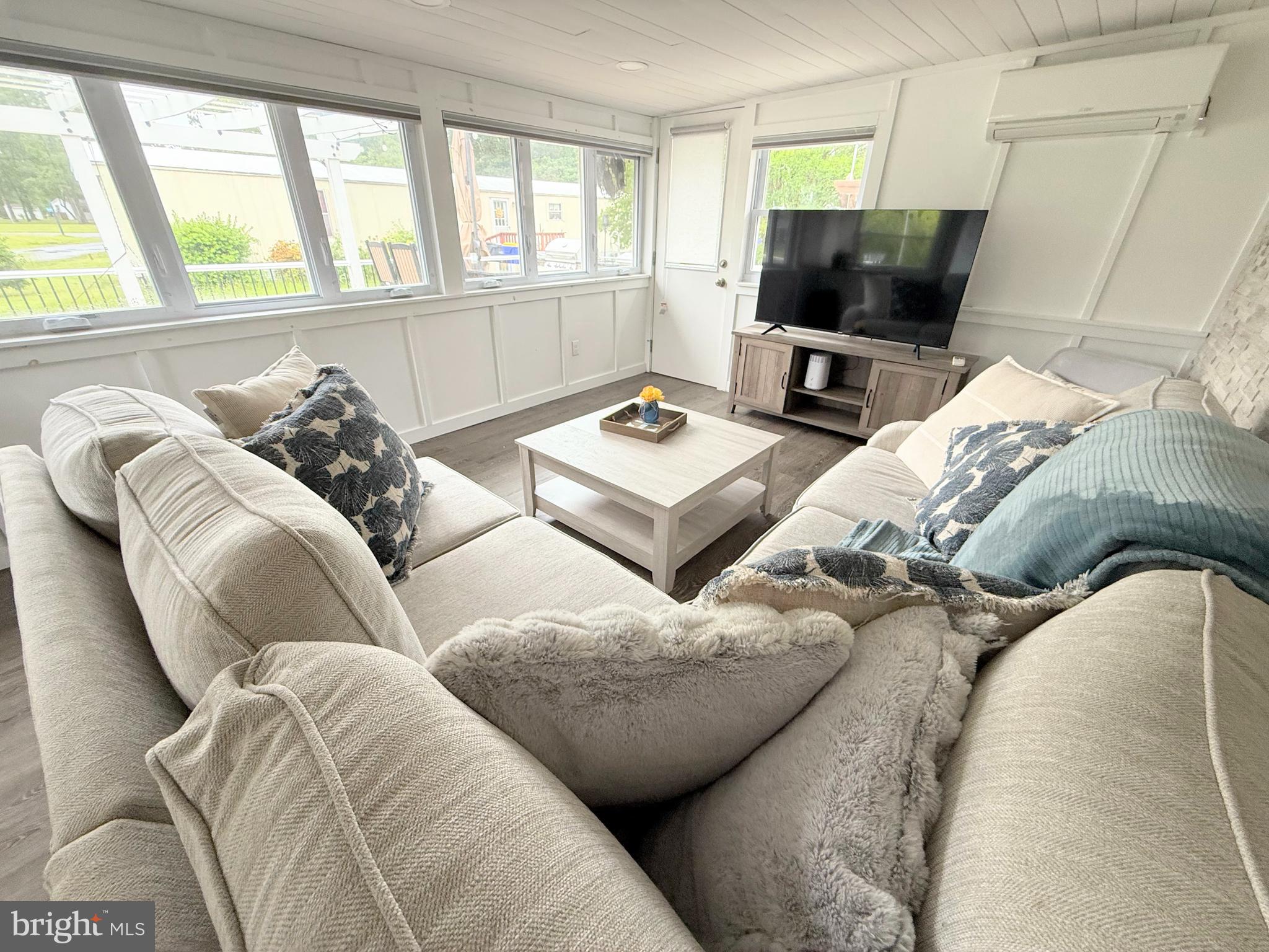 34635 Deck Street, Unit E323 Long Neck, DE 19966 - Photo 15 of 44 a living room with furniture and a flat screen tv