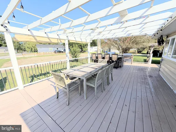 a view of a patio with table and chairs wooden floor and fence