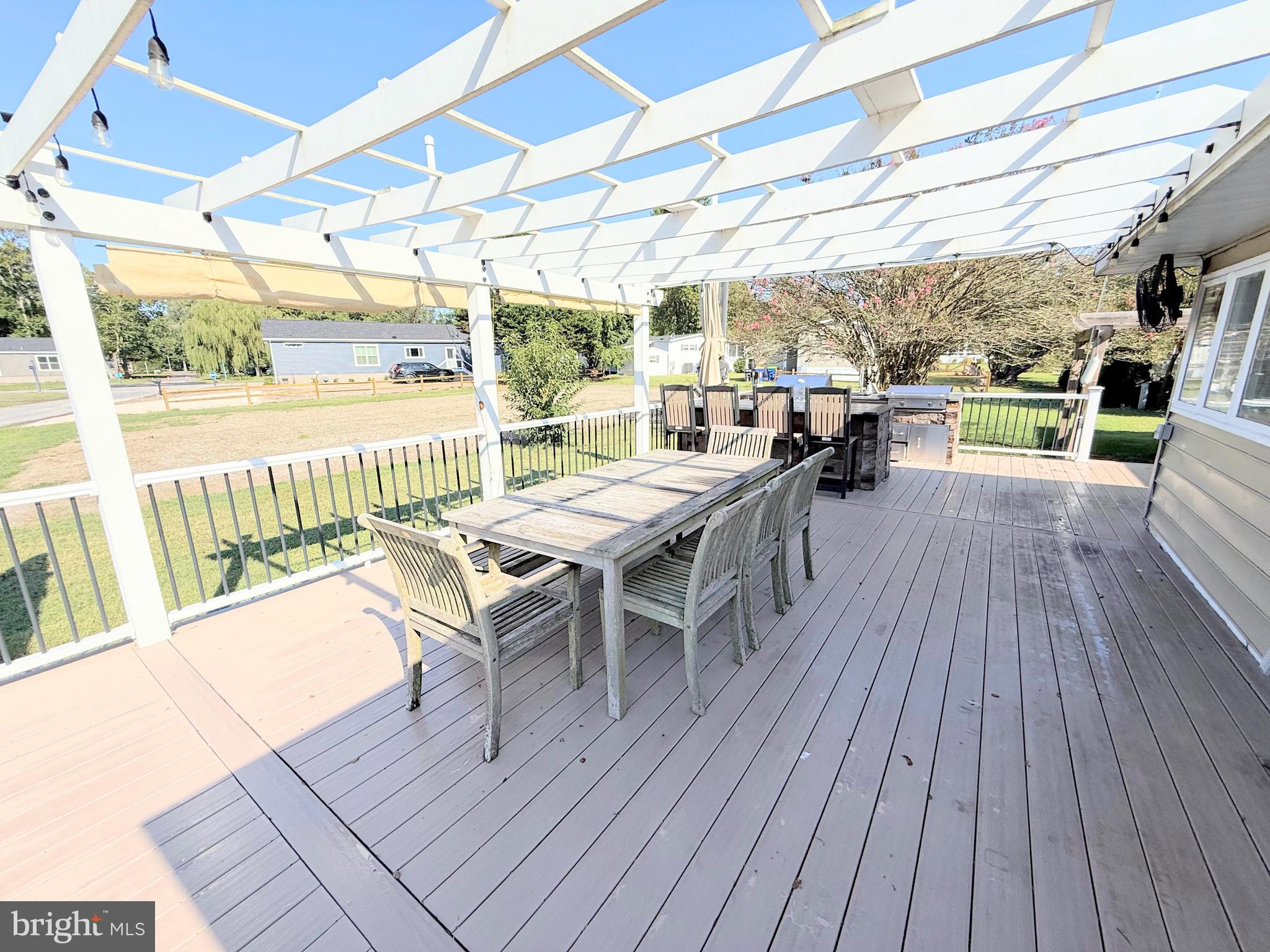 34635 Deck Street, Unit E323 Long Neck, DE 19966 - Photo 2 of 44 a view of a patio with table and chairs wooden floor and fence