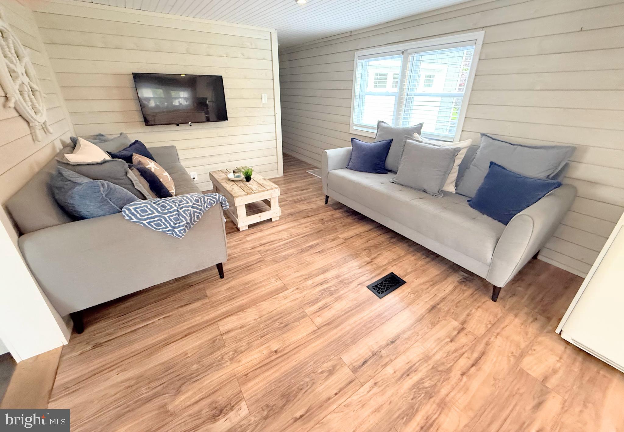 34635 Deck Street, Unit E323 Long Neck, DE 19966 - Photo 21 of 44 a living room with furniture and a flat screen tv