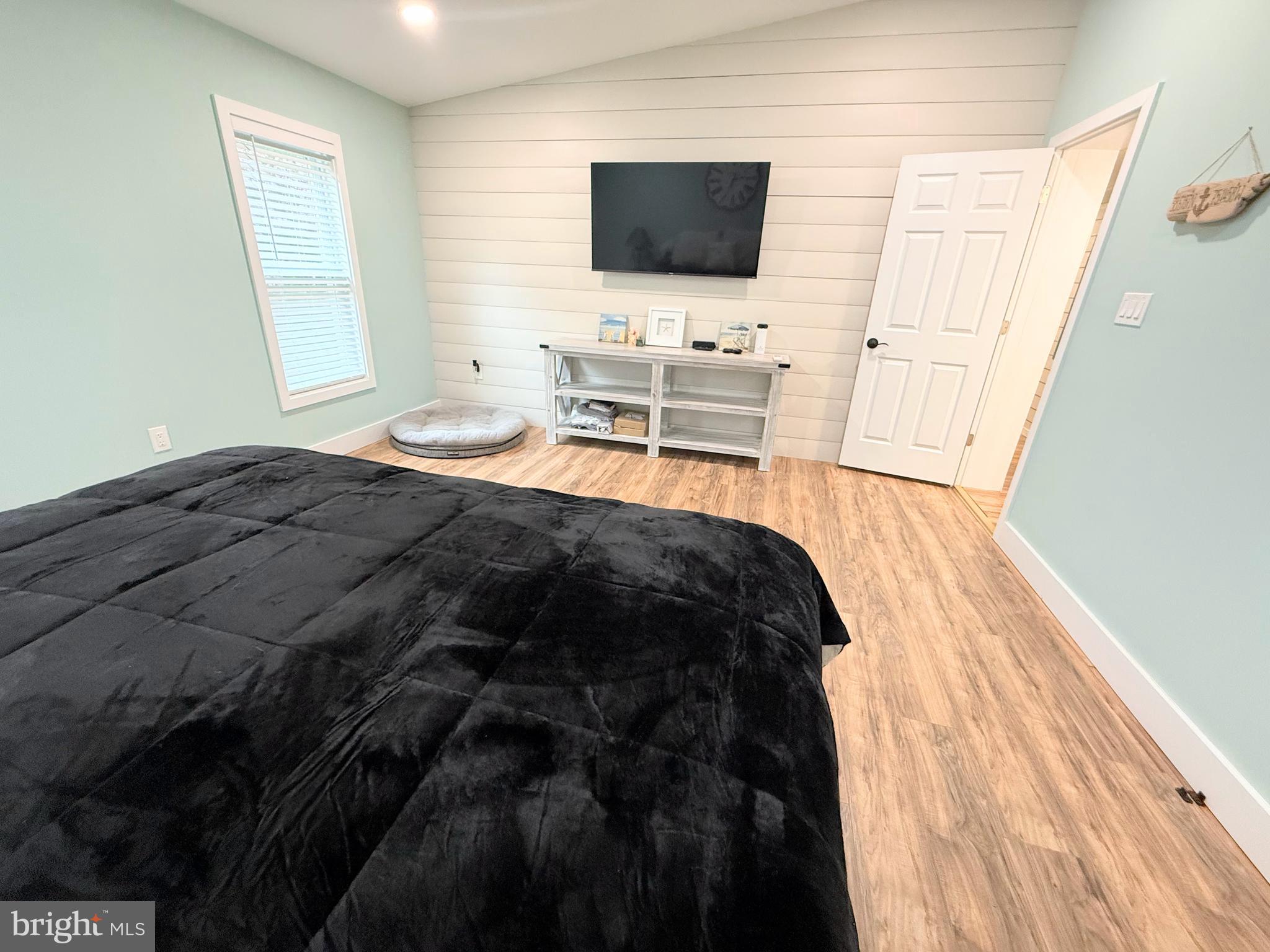 34635 Deck Street, Unit E323 Long Neck, DE 19966 - Photo 27 of 44 a bedroom with a bed and flat screen tv